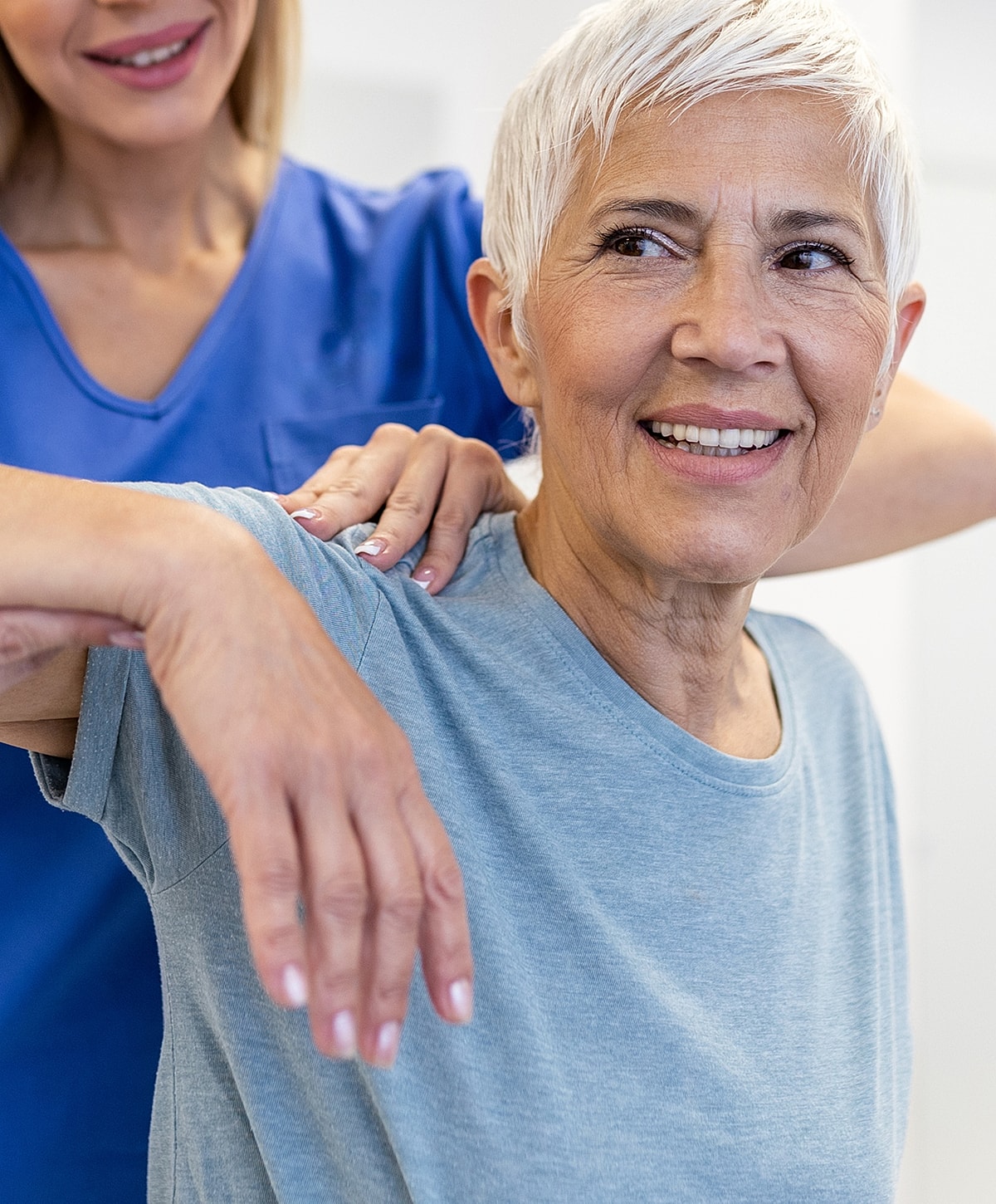 Healthcare professional assisting elderly patient with therapy.